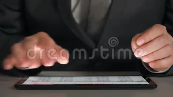 商人在平板电脑上工作分析图表和表格动手特写视频的预览图