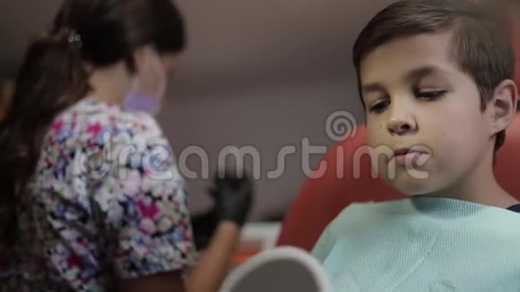女牙医在工作牙科诊所的儿童病人视频的预览图