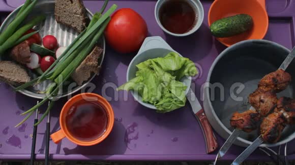 带食物的野餐桌的俯视图吃蔬菜和烤肉的朋友视频的预览图