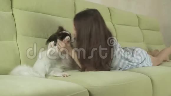 美丽快乐的少女玩她的狗帕皮龙大陆玩具斯皮尔股票录像视频的预览图
