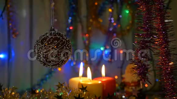 一个大红球新年和圣诞装饰品燃烧蜡烛闪耀的加兰背景模糊视频的预览图