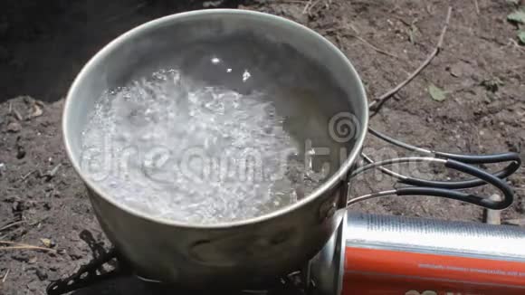 野营炉子上锅里的开水视频的预览图