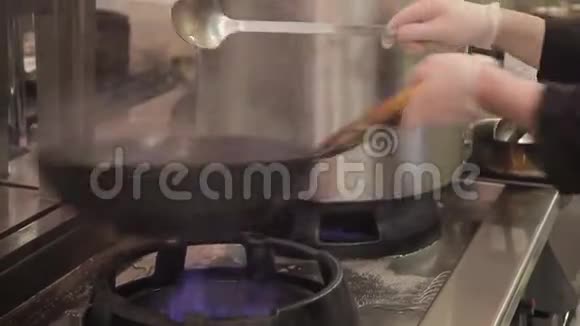 在工业餐厅厨房的灶台上用煎锅搅拌UDON和蔬菜视频的预览图