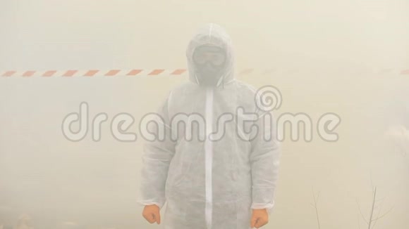 身穿生化防护服戴着防毒面具的男子站在烟雾中视频的预览图