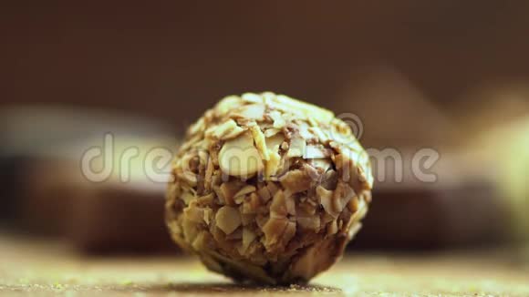 手工制作的巧克力糖果落在木制背景上美味的糖果在缓慢运动的UHD视频的预览图