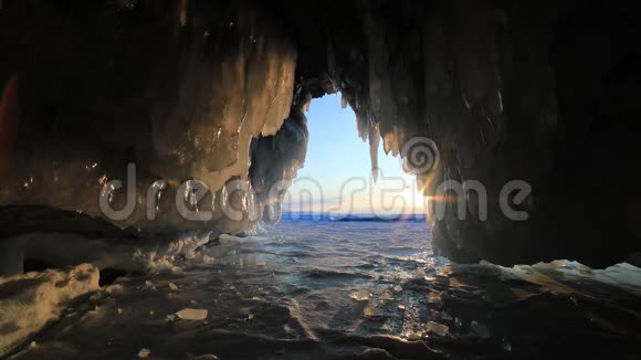 冬季贝加尔湖日落时带冰柱的冰洞视频的预览图