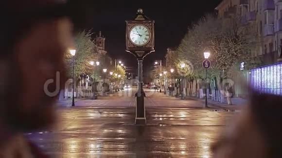 晚上两个情人在公园的美丽城市钟上接吻视频的预览图