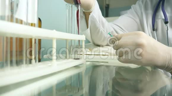 男性医生的手从注射器到试管中注入血液关门视频的预览图