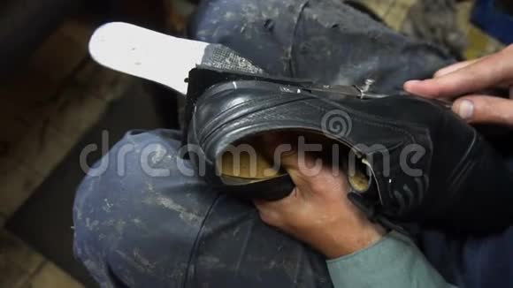 鞋匠在4k车间修理一只鞋把鞋带上的丝锥割下来视频的预览图