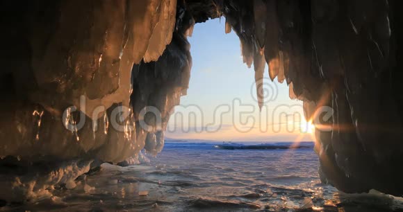 冬季贝加尔湖日落时带冰柱的冰洞视频的预览图
