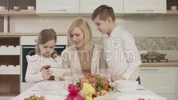 家庭聚餐时妈妈在餐桌上与孩子交流视频的预览图