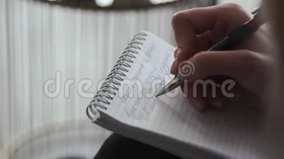 一个人在笔记本上写字视频的预览图