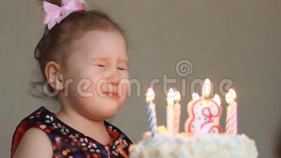 生日快乐可爱的孩子许个愿在聚会上吹灭蛋糕上的蜡烛派对上有趣的小女孩视频的预览图