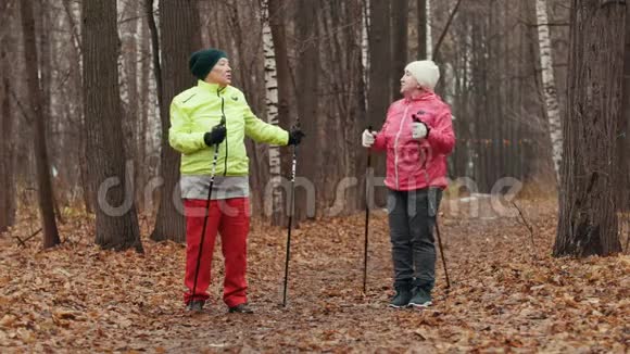 秋日公园里的老太太在北欧黄叶间散步前做热身视频的预览图