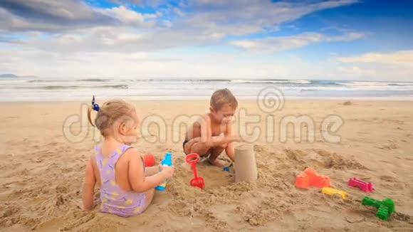小女孩玩耍尝试在沙滩上做沙蛋糕视频的预览图