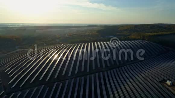 空中无人机镜头在秋天的日落季节飞越太阳能电池板农场视频的预览图
