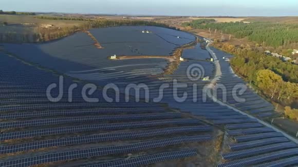 空中无人机镜头在秋天的日落季节飞越太阳能电池板农场视频的预览图