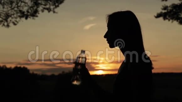 年轻女子饮水剪影视频的预览图