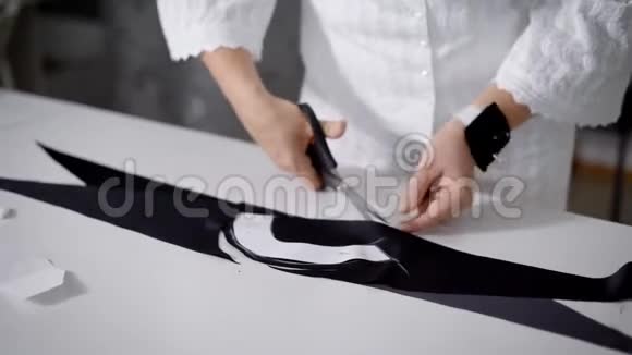 用针垫用剪刀在白色桌子上剪黑布把女性的手收起来女人的身体形象视频的预览图