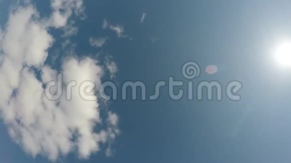 在明亮的阳光下旋转着蓝色的春天的天空背景是小白云视频的预览图