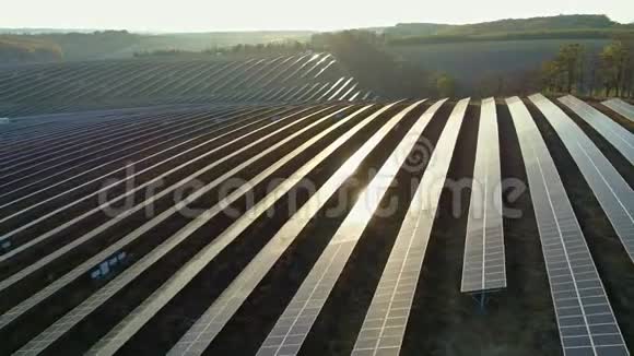 空中无人机镜头在秋天的日落季节飞越太阳能电池板农场视频的预览图
