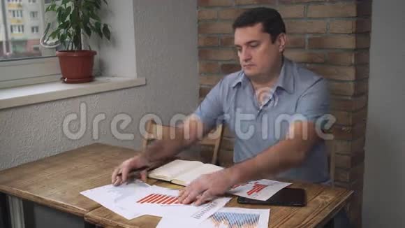 漂亮的中年男子把图形和桌子放在桌子上视频的预览图