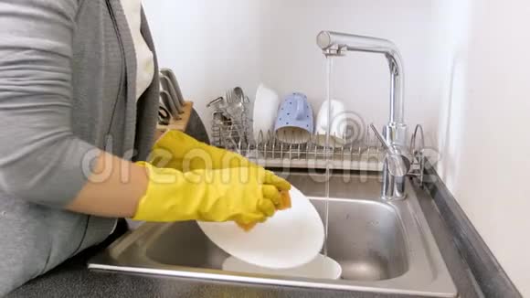 家庭主妇在厨房洗手池洗盘子的4K镜头视频的预览图
