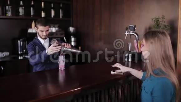 为一个期待坐在酒吧的女孩准备鸡尾酒视频的预览图