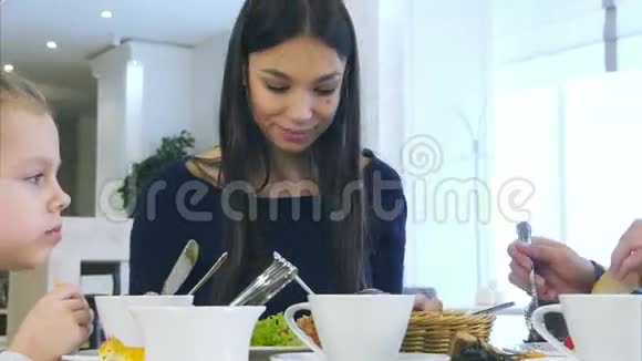 欧洲和谐家庭在咖啡馆里吃健康的午餐他们吃蔬菜沙拉聊天微笑视频的预览图