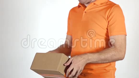 穿橙色制服的快递员扔了一个小包裹浅灰色背景超慢动作特写镜头视频的预览图