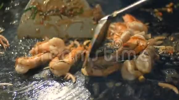 用煎锅中的鸡蛋和海鲜准备泰国面条虾用油在煎锅里煎夜间市场视频的预览图