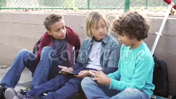 在公园玩手机的男孩子们视频的预览图