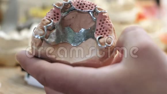 人手中假牙的布局和工作台修复师视频的预览图