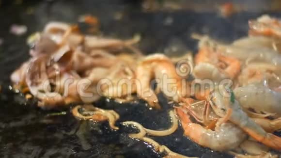 用煎锅中的鸡蛋和海鲜准备泰国面条虾用油在煎锅里煎夜间市场视频的预览图