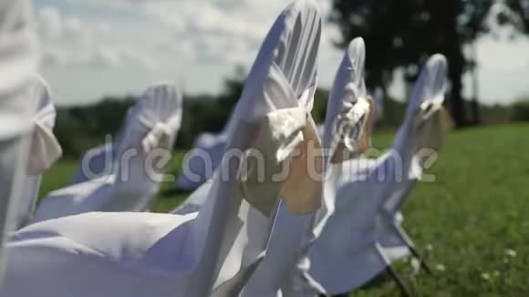 夏季刮风日在户外举行的庆祝婚礼的白色椅子视频的预览图