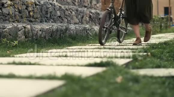 在城市街道上女性的脚走在骑自行车的旁边女子自行车城视频的预览图
