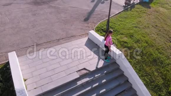 一个年轻女孩跑上楼梯运动空中射击视频的预览图