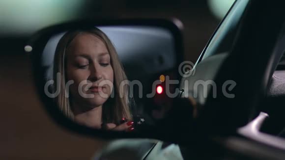 年轻女子在车里涂红唇膏视频的预览图