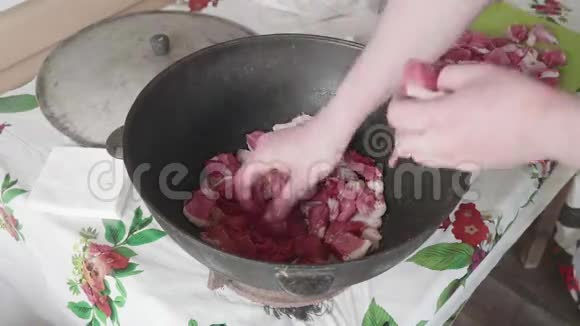 男性厨师将肉片放入大锅中同时烹饪圆顶视频的预览图