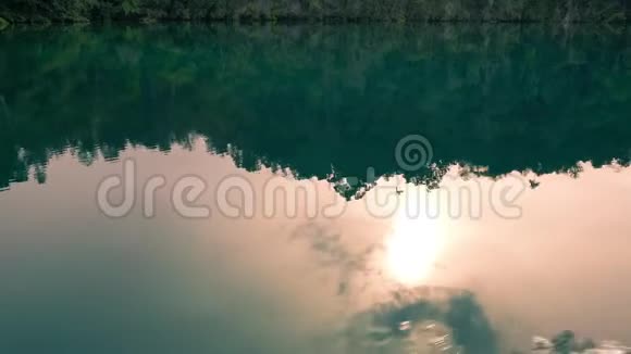 太阳反射在Gam岛前面的水面上在通往隐藏海湾的路上通过通道RajaAmpat西巴布亚视频的预览图