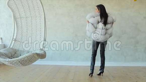 穿着羊皮大衣的时髦迷人的女人在工作室里摆姿势视频的预览图