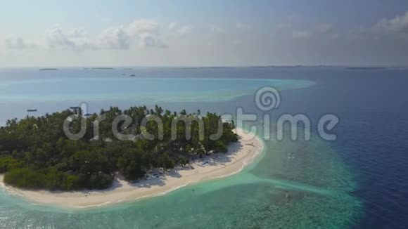 镜头掠过马尔代夫热带岛屿度假酒店酒店内有白色的沙滩棕榈树和绿松石色的印度洋视频的预览图