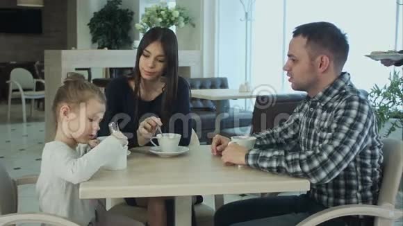 年轻的家庭在咖啡馆或餐馆吃饭服务员犯了一个错误混淆了盘子父亲和母亲视频的预览图