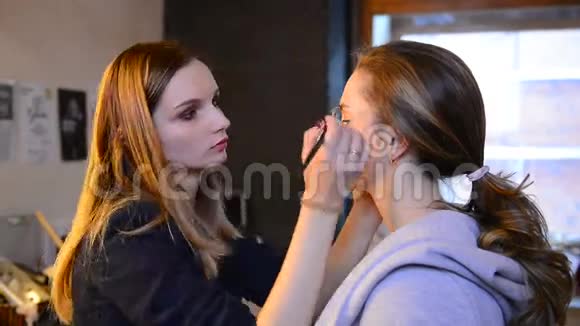 在美容院女性化妆刷在模特脸上化妆视频的预览图