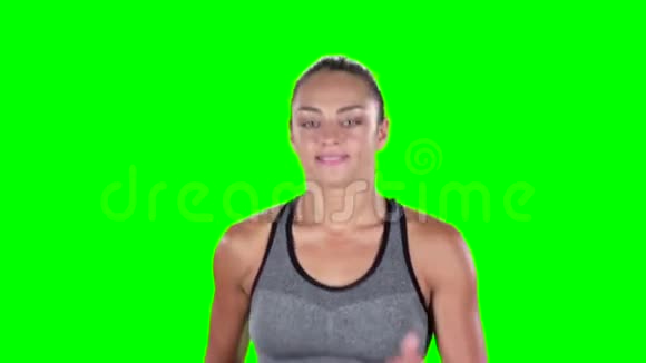 女运动员跑步女孩前面绿色屏幕慢动作视频的预览图