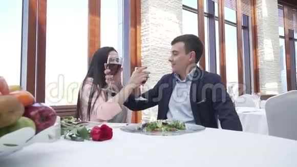 一对情侣在饭店里喝红酒为兄弟情谊和亲吻股票视频视频的预览图