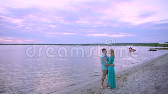 湖岸上一对相爱的情侣拥抱亲吻那人拿起脚后跟转动着视频的预览图