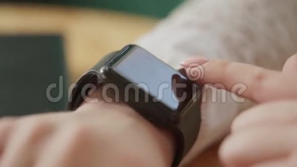 宏拍了一个年轻女人手她使用了一个新的小玩意一个智能手表视频的预览图