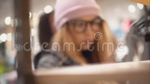 一位时髦的时髦女性来到商店货架选择新眼镜模糊的视频的预览图