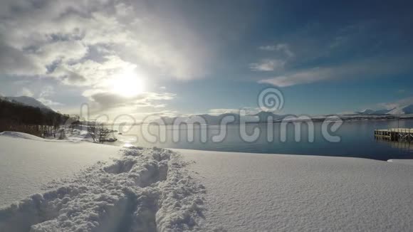 带着金色阳光蓝天和峡湾的小山径的雪片视频的预览图
